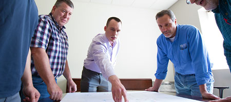 Engineers gathered around an illuminated conference table.