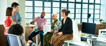 An ethnically and sex diversified group meeting lead by an African-American man