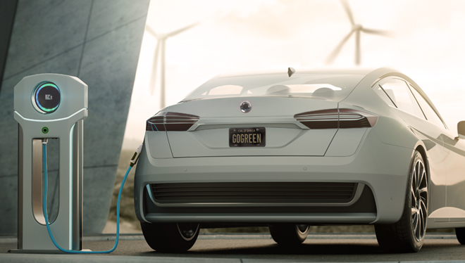 Image shows an electric car being charged next to a home. In the far distance are several wind turbines.