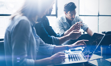 A team of 3 collaberating on a project in a office.