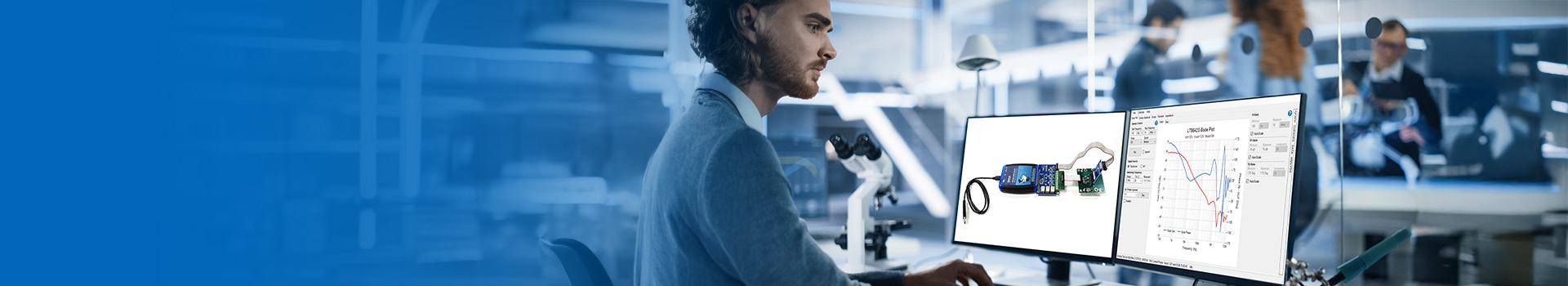 Engineer analyzing power system data on dual monitors in a modern lab setting