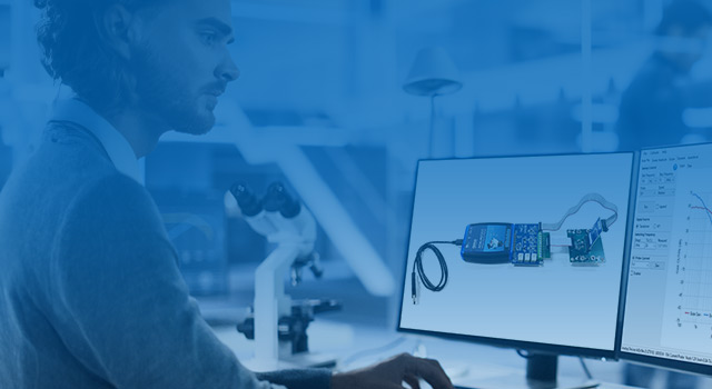 Engineer analyzing power system data on dual monitors in a modern lab setting