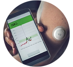 Person holding smartphone showing glucose reading of 119, next to sensor on their upper arm.