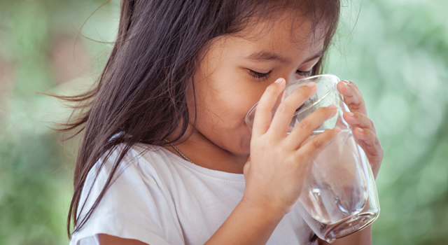girl drinking fresh water from glass