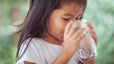girl drinking fresh water from glass