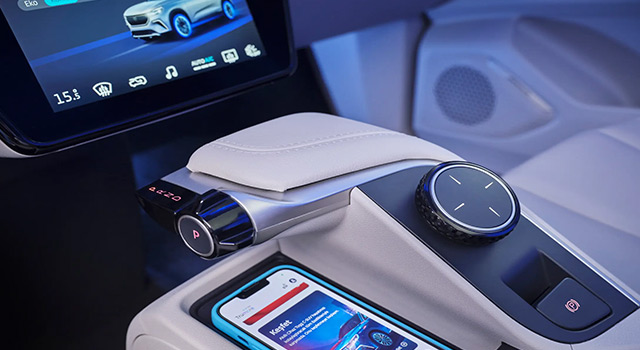 Modern car with an advanced digital dashboard, touchscreen controls, and a smartphone placed on a wireless charging pad, highlighting smart automotive technology.