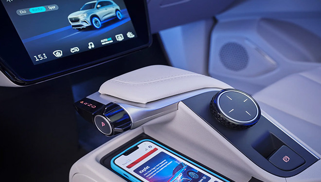 Modern car with an advanced digital dashboard, touchscreen controls, and a smartphone placed on a wireless charging pad, highlighting smart automotive technology.