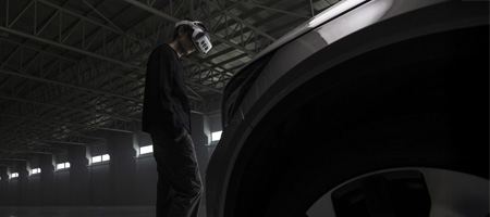 man wearing a varjo headset walking towards a vehicle